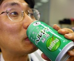 TOKYO, JAPAN:  A Japanese businessman drinks Healthya Green Tea at his office in Tokyo 20 August 2004. Scores of convenience stores in the Japanese capital's business district kick off a typical weekday with a morning ritual: commuters in both suits and casual wear form a long queue at the cashier with small bottles of "healthy" green tea drinks in hand. AFP PHOTO/Yoshikazu TSUNO  (Photo credit should read YOSHIKAZU TSUNO/AFP/Getty Images)