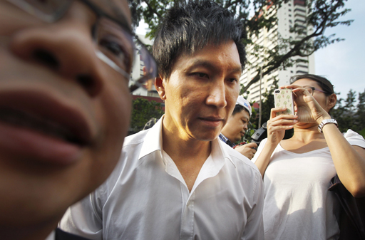In this July 12, 2012, file photo, City Harvest Church founder Kong Hee, center, is surrounded by the media as he arrives at the Subordinate Courts in Singapore. The founder of the popular Singapore church has been found guilty Wednesday, Oct. 21, 2015, of misappropriating about $35 million in donations to support his wife's singing career in Asia before helping her break into the U.S. market for evangelization purposes. (AP Photo/Wong Maye-E, File)