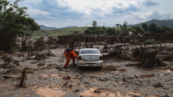 epaselect epa05017287 Firefighters search for victims in the mud after an industrial waste dump collapsed, in Bento Rodrigues in Mariana, Brazil, 08 November 2015. Retaining walls that burst open on 05 November at a mining complex set off an avalanche of mud and mineral residues that buried dozens of homes in the southeastern Brazilian city of Mariana and left at least one person dead, 16 injured, 13 missing and 530 homeless.  EPA/Antonio Lacerda