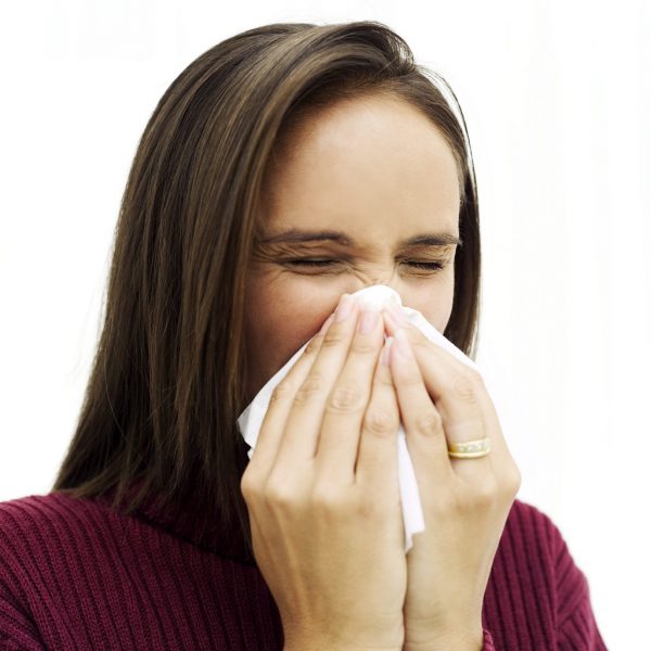 Young Woman Sneezing into a Handkerchief --- Image by © Royalty-Free/Corbis